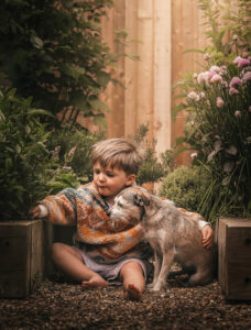 Menino com cachorro no jardim, fotografia premiada em concurso de fotos de animais em jardins 