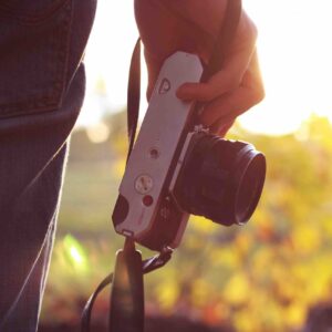 Fotógrafo segura câmera sob luz do sol na natureza