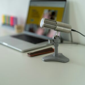Computador e microfone sobre mesa