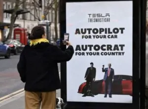 Mulher fotografa cartaz de protesto contra Elon Musk em Londres