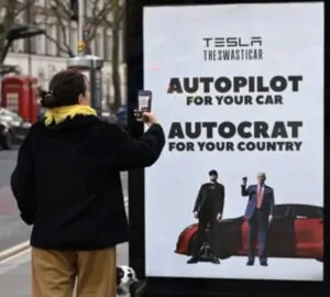 Mulher fotografa cartaz de protesto contra Elon Musk em Londres