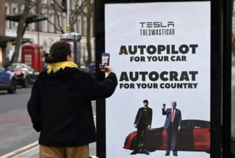 Mulher fotografa cartaz de protesto contra Elon Musk em Londres