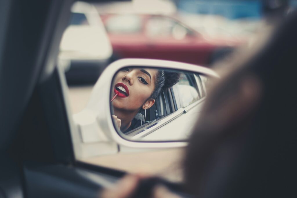 Mulher refletida no retrovisor de um carro