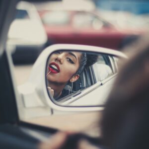 Mulher refletida no retrovisor de um carro