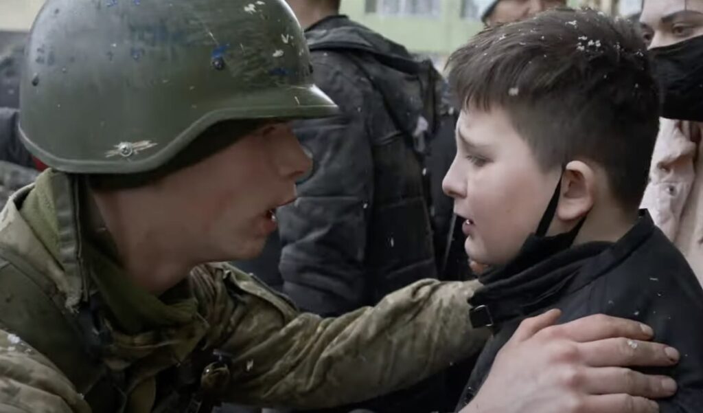 Soldado ucraniano com criança no cerco a Mariupol, cena do documentário indicado ao Oscar