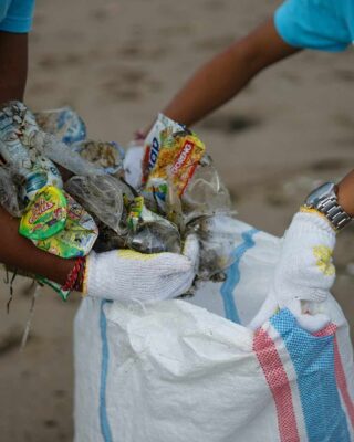 homens recolhem lixo na praia, uma das soluções para o problema de resíduos sólidos