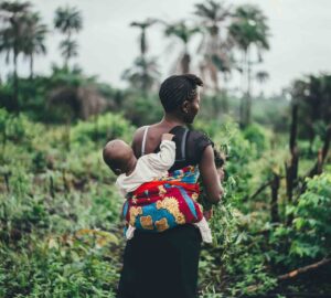 Mulher carrega criança nas costas em Serra Leoa