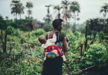 Mulher carrega criança nas costas em Serra Leoa