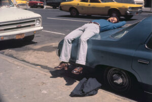 Homem deitado sobre carro em Nova York, fotografia de Helen Levitt 