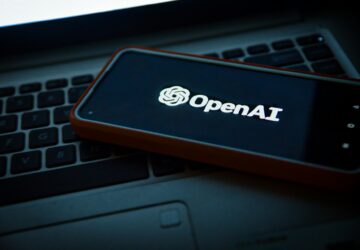 Teclado e smartphone com logomarca da OpenAI, empresa de IA generativa
