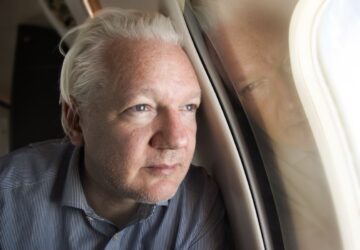 Julian Assange no avião em que deixou o Reino Unido