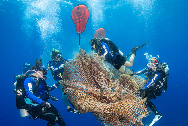 Voluntários removem rede de pesca abandonada no mar do Havaí, imagem vencedora do concurso de fotos do oceano da ONU em 2024
