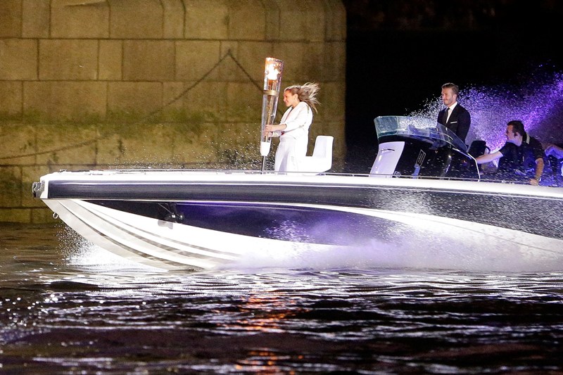 David Beckham e a portadora da tocha olímpica chegam em uma lancha na cerimônia de abertura das Olimpíadas de Londres