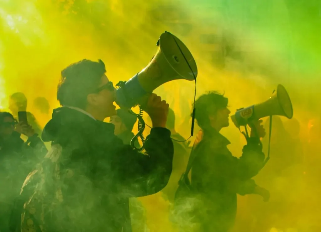 Homens com megafone em passeata ativismo liberdade de expressão