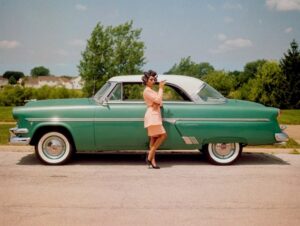 Mulher posando na frente de um carro em Crestline, EUA. A foto foi uma das premiadas no concurso de fotos coloridas