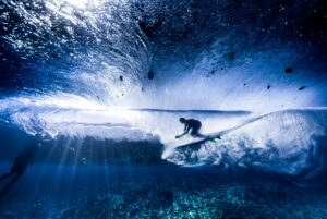Surfista deslizando em uma onda na Polinésia Francesa. A foto ganhou o primeiro lugar na categoria subaquático