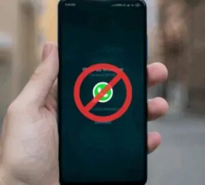 Mão segurando smartphone com o aplicativo WhatsApp e um sinal de proibido em vermelho sobre ele, simbolizando o possível bloqueio do WhatsApp na Rússia.