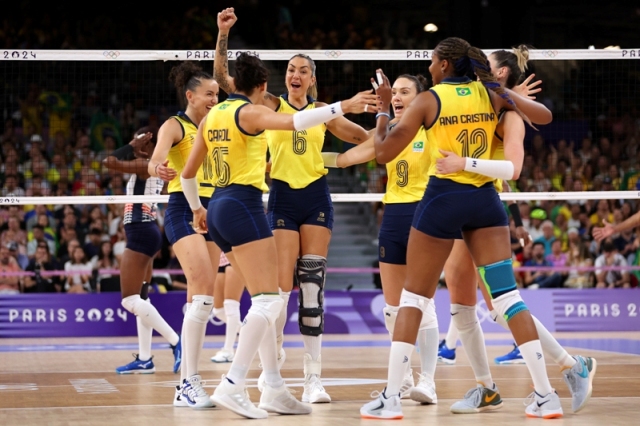 Equipe de vôlei feminina comemora a vitória nas quartas de final