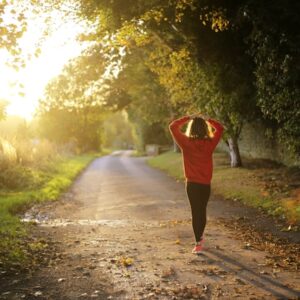 Mulher caminhando em trilha sob o sol