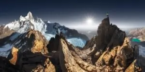 Imagem panorâmica do Fritz Roy, com a geleira ao fundo e um homem no pico da montanha. A foto foi uma das vencedoras do concurso de fotografia colorida