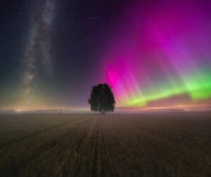 O céu iluminado pelas cores da aurora boreal e a Via Láctea. A imagem foi capturada na Letònia