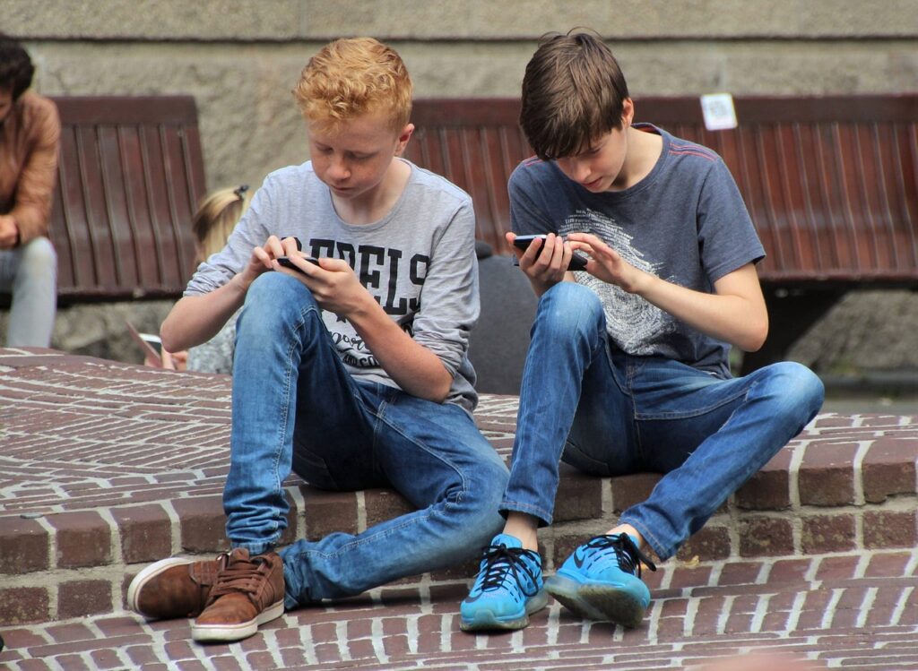 dois meninos lendo conteúdo no smartphone