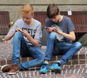 dois meninos lendo conteúdo no smartphone