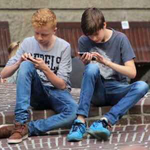 dois meninos lendo conteúdo no smartphone