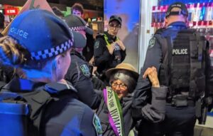 Mulher sendo presa em protesto do grupo ambientalista Extinction Rebellion