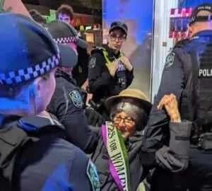 Mulher sendo presa em protesto do grupo ambientalista Extinction Rebellion