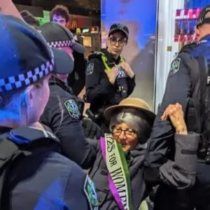 Mulher sendo presa em protesto do grupo ambientalista Extinction Rebellion