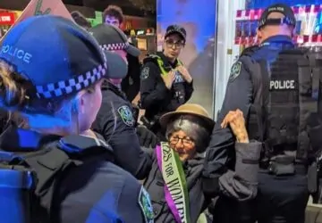 Mulher sendo presa em protesto do grupo ambientalista Extinction Rebellion