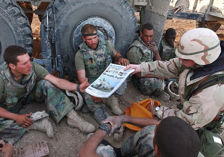 Sargento distribui exemplar do jornal americano militar Stars and Stripes a soldados.