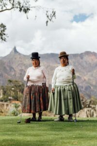 Duas amigas posam em trajes tradicionais bolivianos em um campo de golfe em La Paz, Bolívia. Fotografia finalista do Sony World Photography Awards