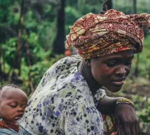 Mulher de turbante com filho na floresta