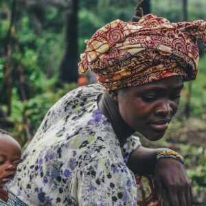 Mulher de turbante com filho na floresta