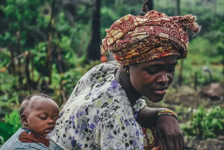 Mulher de turbante com filho na floresta