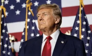 Donald Trump com bandeiras dos EUA ao fundo