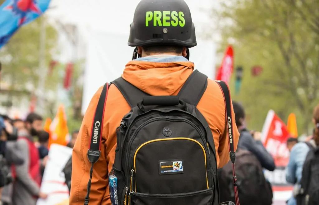 Profissional de imprensa com capacete Press