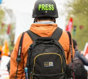 Profissional de imprensa com capacete Press
