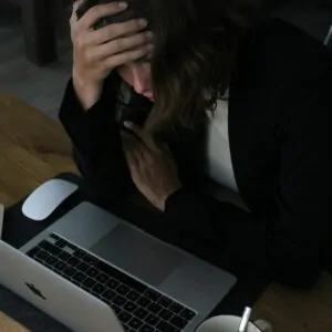 Mulher jovem lendo no conmputador com ar preocupado