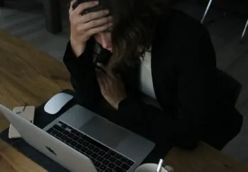 Mulher jovem lendo no conmputador com ar preocupado