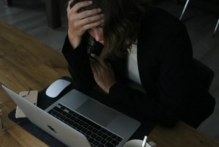 Mulher jovem lendo no conmputador com ar preocupado