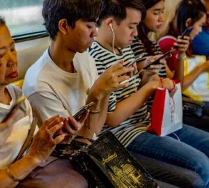 pessoas no metrô lendo no smartphone, usado cada vez mais para consumo de notícias nas redes sociais