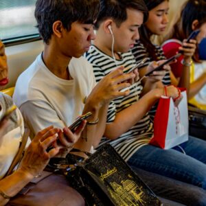 pessoas no metrô lendo no smartphone, usado cada vez mais para consumo de notícias nas redes sociais