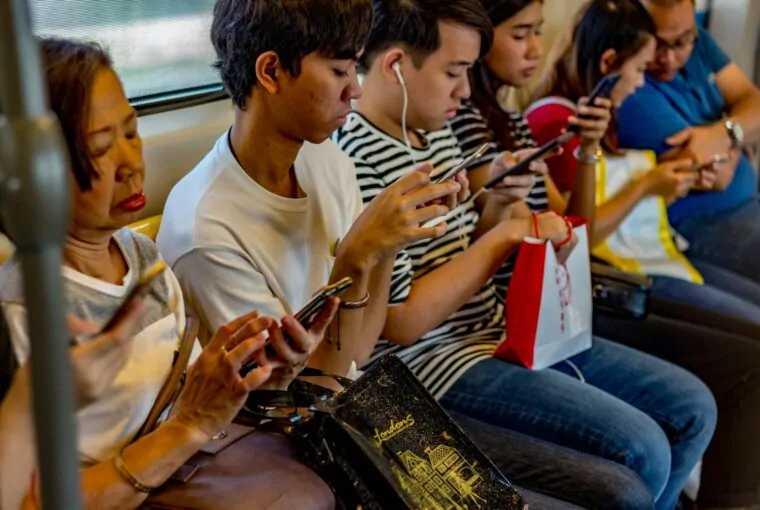 pessoas no metrô lendo no smartphone, usado cada vez mais para consumo de notícias nas redes sociais