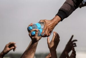 Mãos esticadas pegando garrafas de água em Gaza, foi uma das finalistas do concurso de fotografia de tempestade