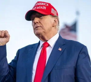 Donald Trump com boné MAGA e punho cerrado