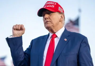 Donald Trump com boné MAGA e punho cerrado