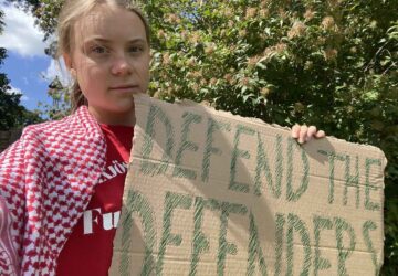 Greta Thumberg, ativista ambiental, segurando cartaz contra violência voltada a ativistas ambientais